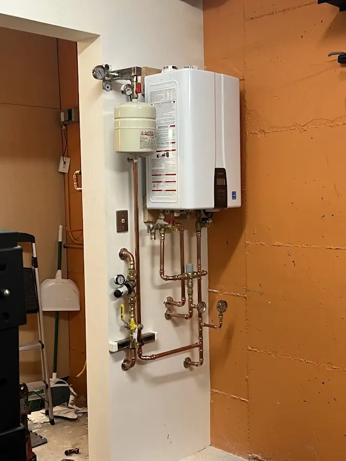 Plumbing technician inspecting water heater connections in Highland